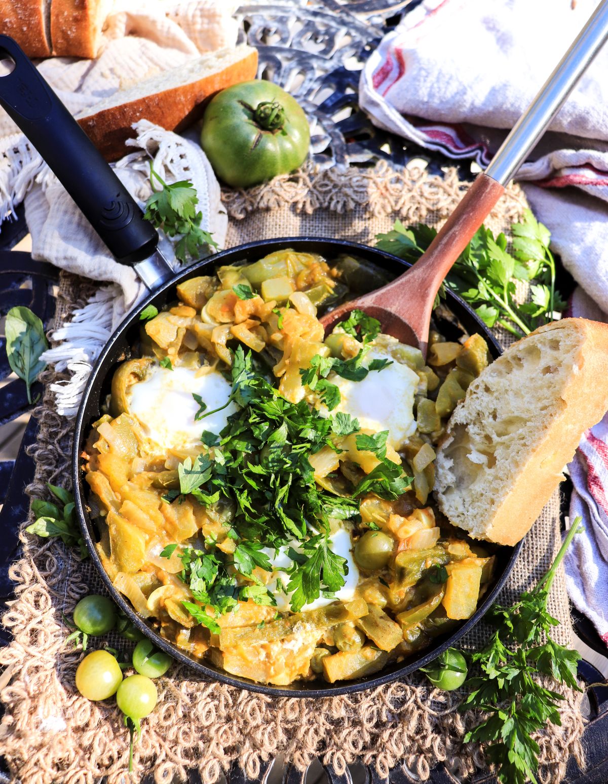 shakshuka with green tomatoes and peppers served in a skillet